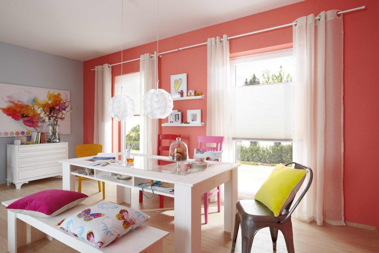 Salle à manger lumineuse avec table, chaises, banc, rideaux et suspensions