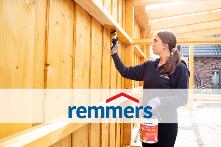 Une femme peint du bois avec une crème de protection du bois Remmers
