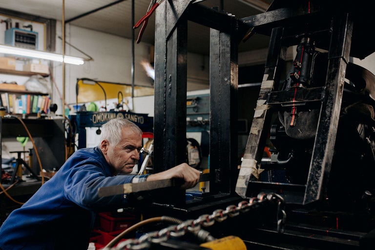 Un artisan travaille avec un banc de redressage dans un atelier.