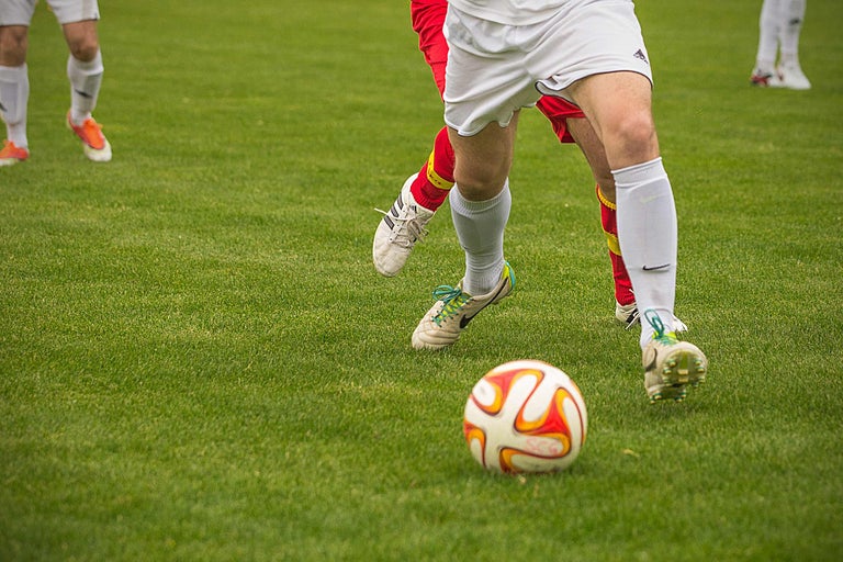 Joueurs de football sur une pelouse verte avec un ballon de football