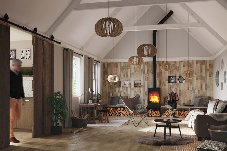 Salon confortable de style campagnard avec cheminée, lambris en bois, suspensions et porte coulissante