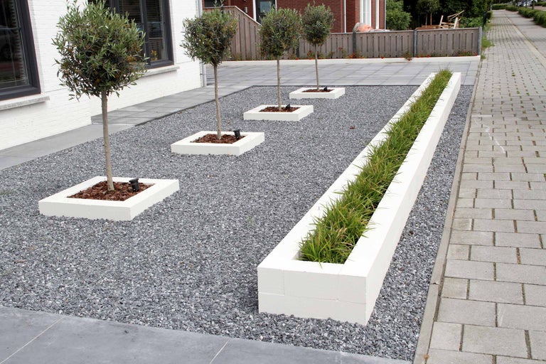 Garten mit Bäumen in quadratischen Pflanzgefässen, einem länglichen Pflanzgefäss und Kies