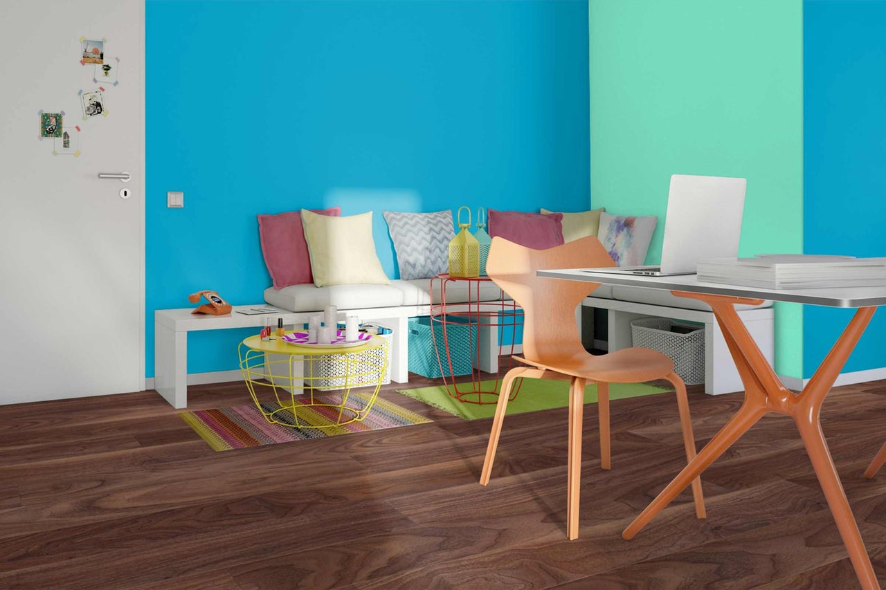 Bureau lumineux avec bureau, chaise, banquette et accessoires colorés sur parquet