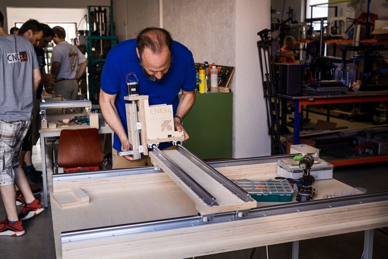 Un homme travaille sur une fraiseuse à bois dans un atelier.