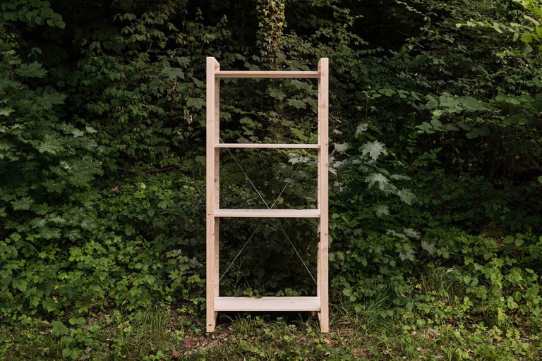 Étagère en bois avec trois tablettes sur fond vert