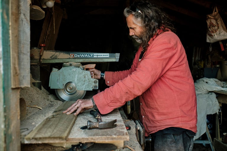 Un homme travaille une planche de bois avec une scie circulaire DeWalt.