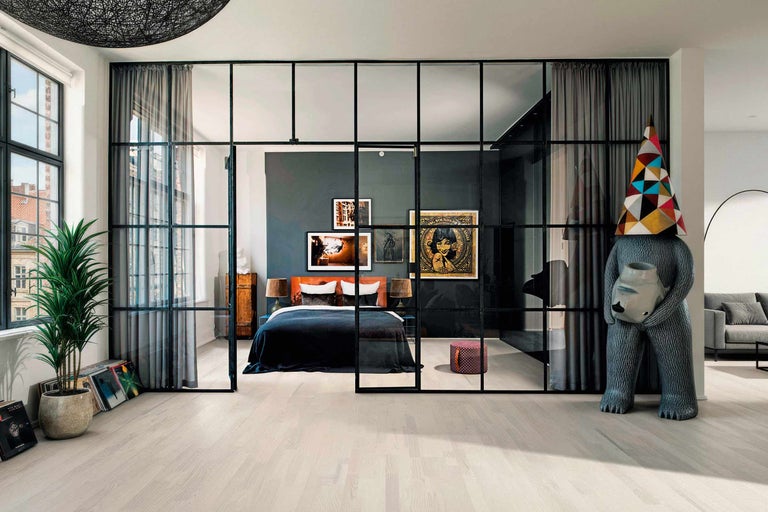 Chambre à coucher avec lit, œuvres d'art et séparation de pièce au design moderne