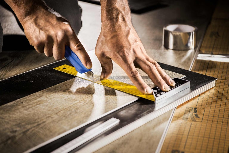 Découpe d'une plaque de stratifié avec un cutter et une équerre