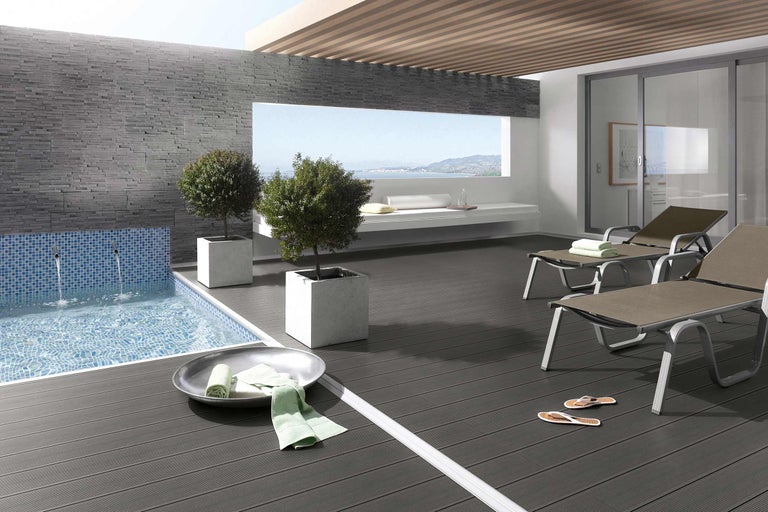 Terrasse avec piscine, chaises longues et bacs à plantes pour une ambiance relaxante