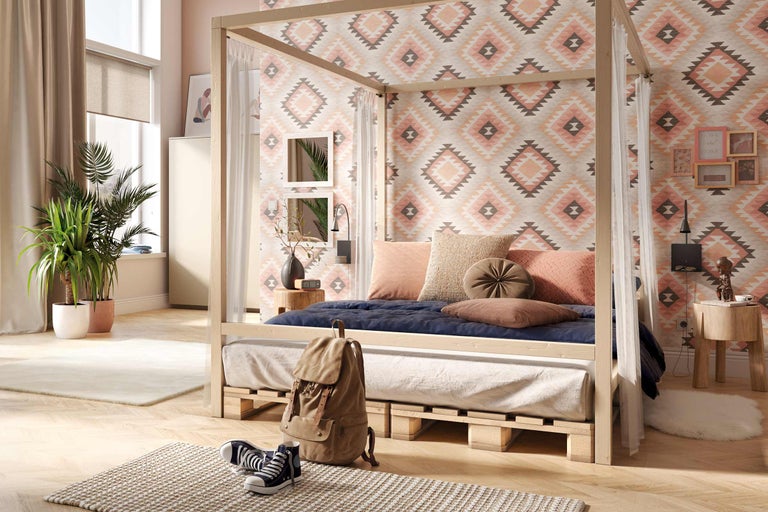 Schlafzimmer mit Himmelbett auf Holzpaletten und gemusterter Tapete