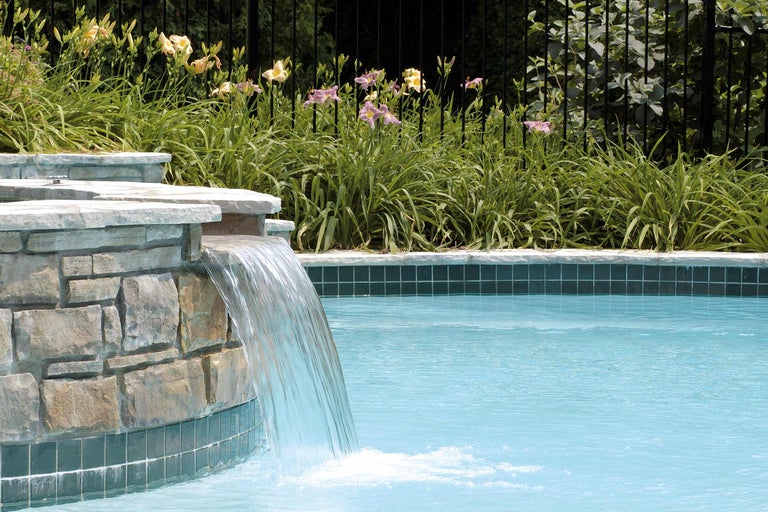Piscine avec cascade et mur de pierre