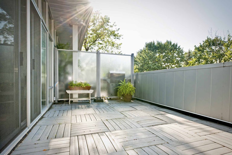 Balcon lumineux avec dalles en bois et écran de confidentialité