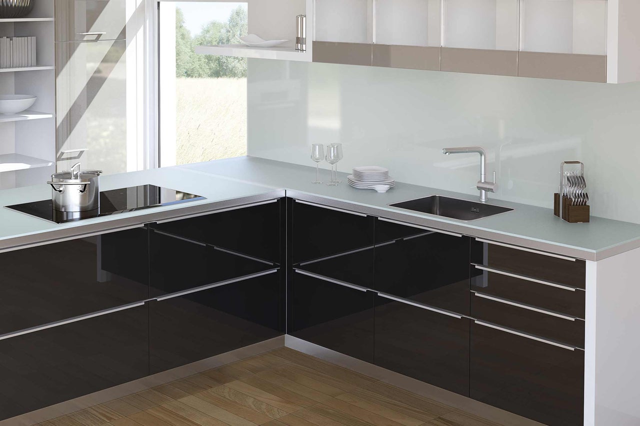 Cuisine moderne avec armoires noires, évier et plaque de cuisson.