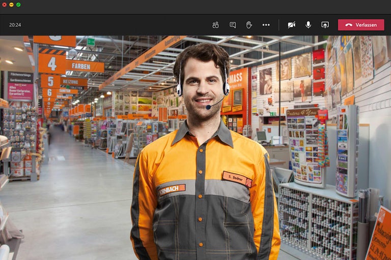 Un employé Hornbach avec un casque devant un magasin Hornbach en arrière-plan.