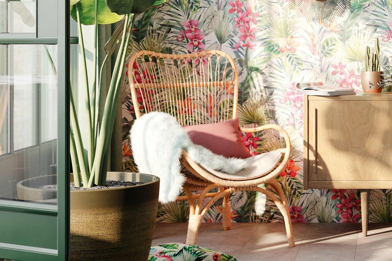 Dekorativer Innenraum mit Rattansessel, Zimmerpflanze und Blumenvliestapete für eine helle und freundliche Atmosphäre