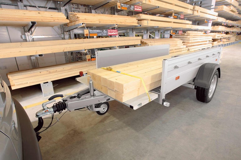Une remorque chargée de planches de bois dans la quincaillerie Hornbach.