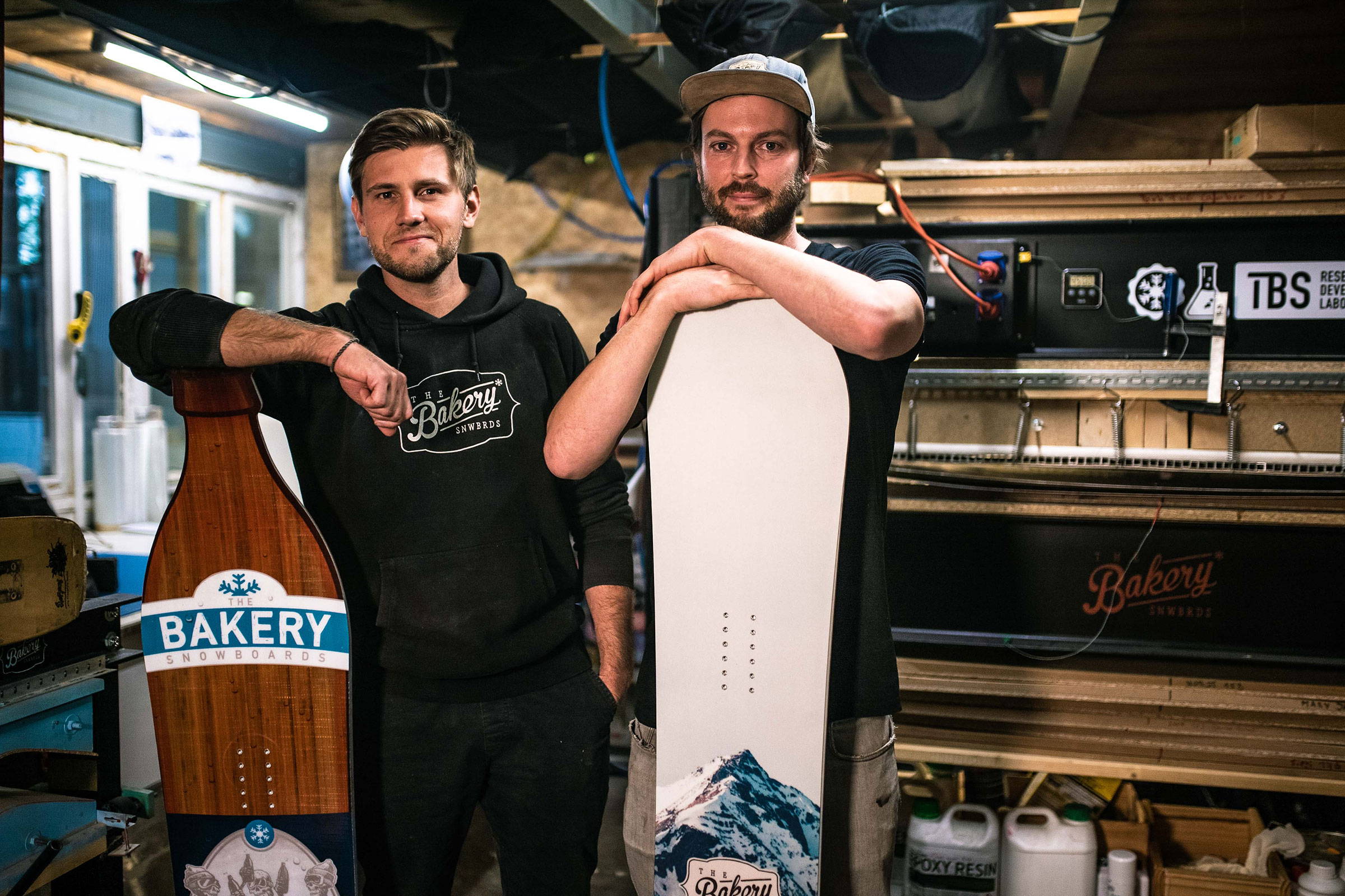 Zwei Männer präsentieren Snowboards der Marke Bakery Snowboards.
