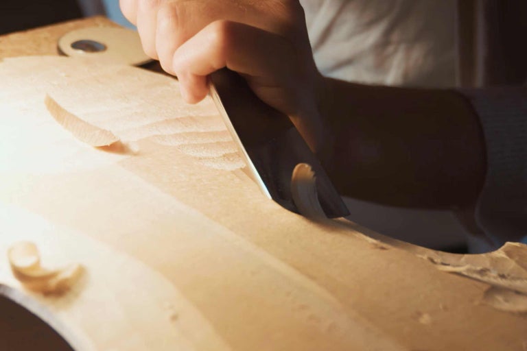 Handwerker bearbeitet Holz mit einem Stecheisen