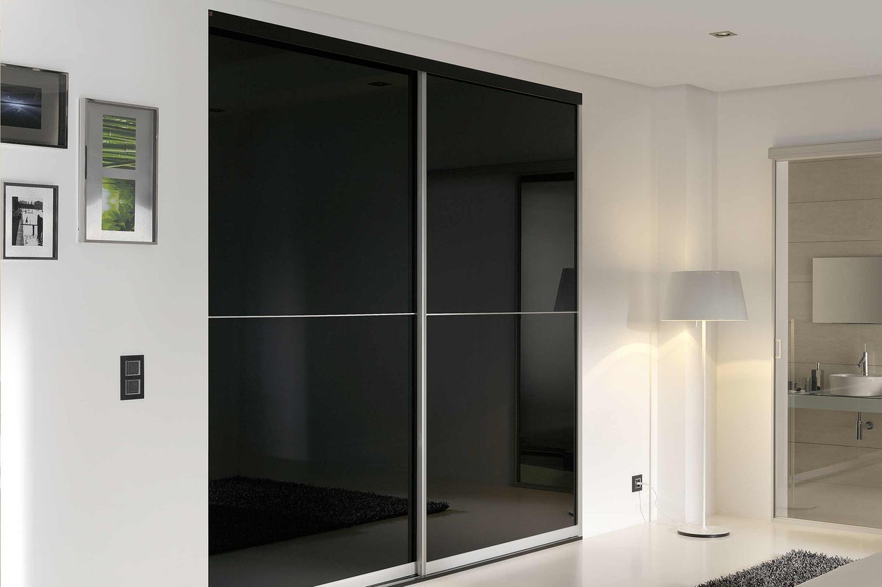 Schlafzimmer mit Schiebetürenschrank und Stehlampe