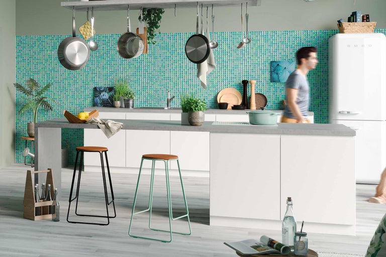 Cuisine lumineuse avec ustensiles de cuisine, carreaux de mosaïque et tabourets de bar