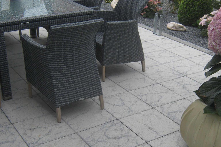 Salon de jardin avec table et chaises sur dalles en pierre