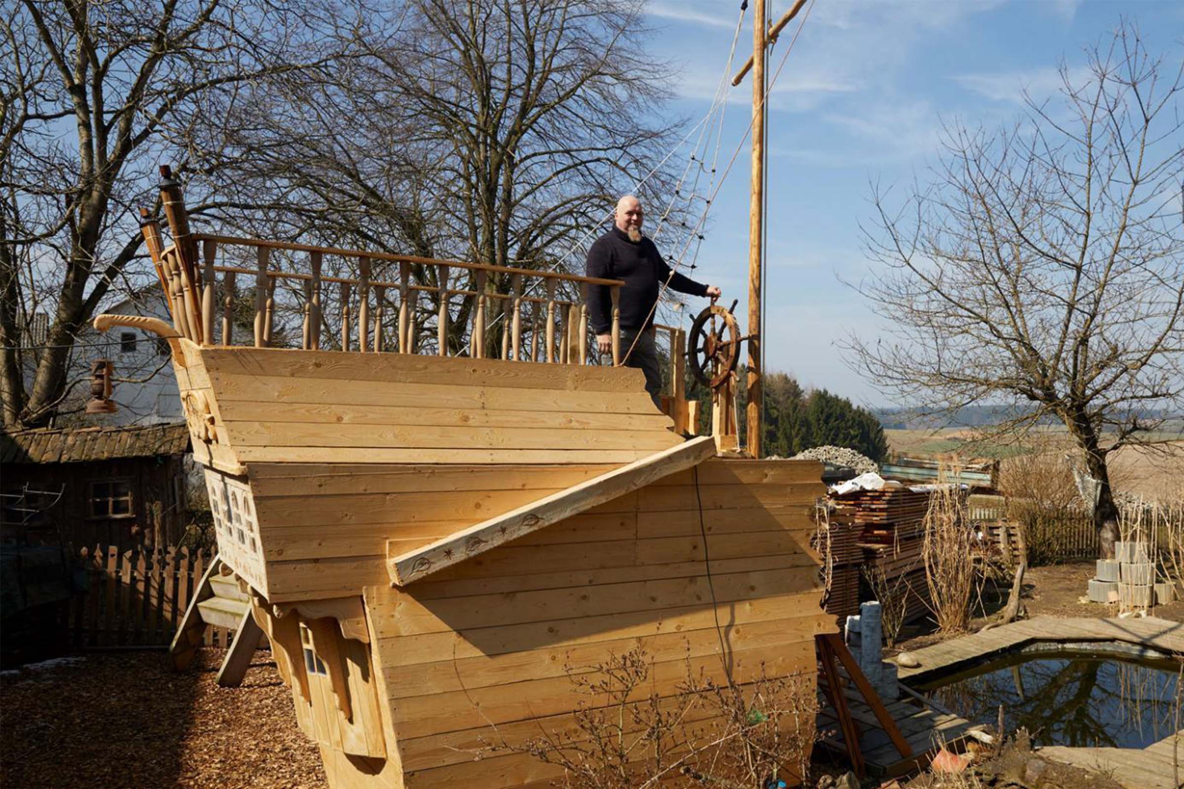 Bateau de jeu en bois dans le jardin avec un homme à la barre
