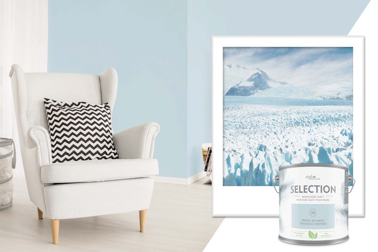 Szene mit Sessel, gerahmtem Gletscherbild und Dose matter Wandfarbe