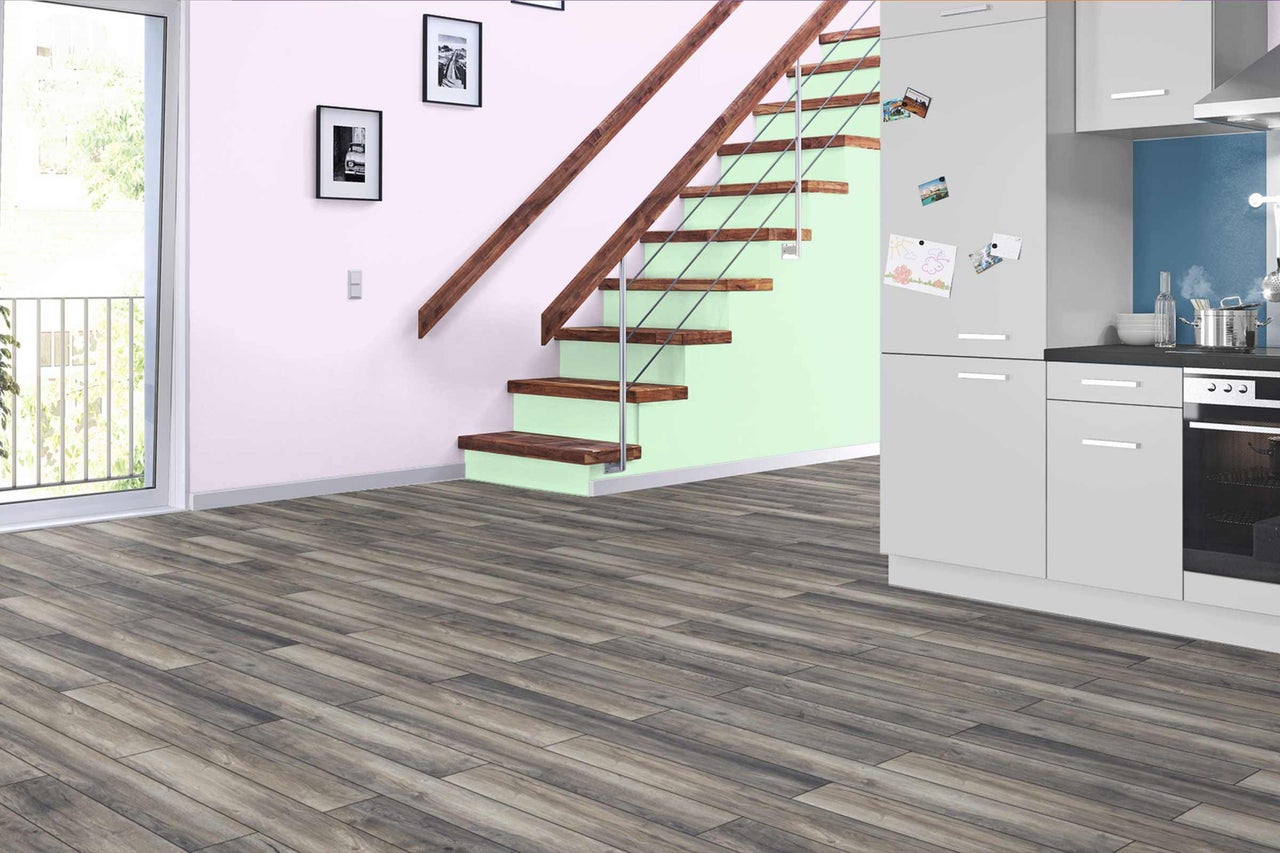 Pièce lumineuse avec plancher en bois, escalier et kitchenette