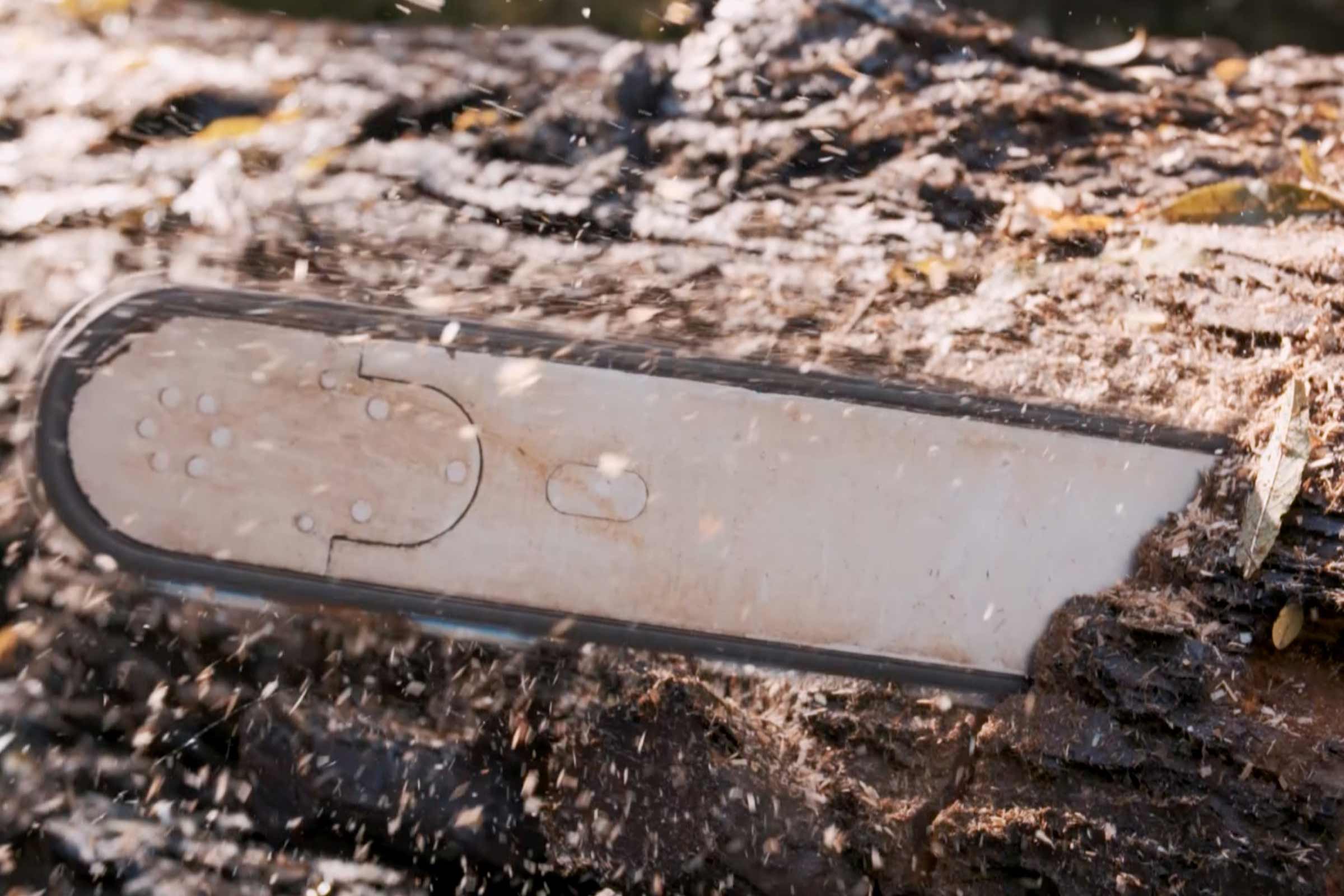 Gros plan d'une tronçonneuse coupant du bois