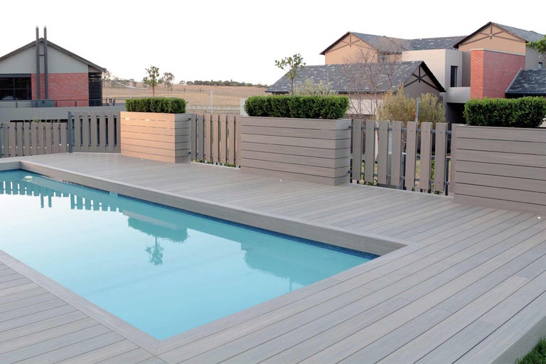 Piscine avec terrasse en bois et bacs à plantes décoratifs