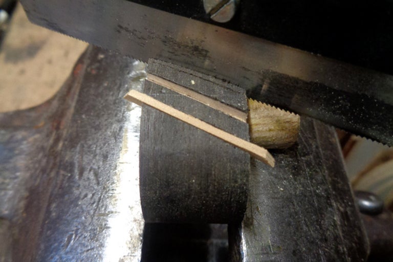 Scie à métaux coupant du bois dans un étau