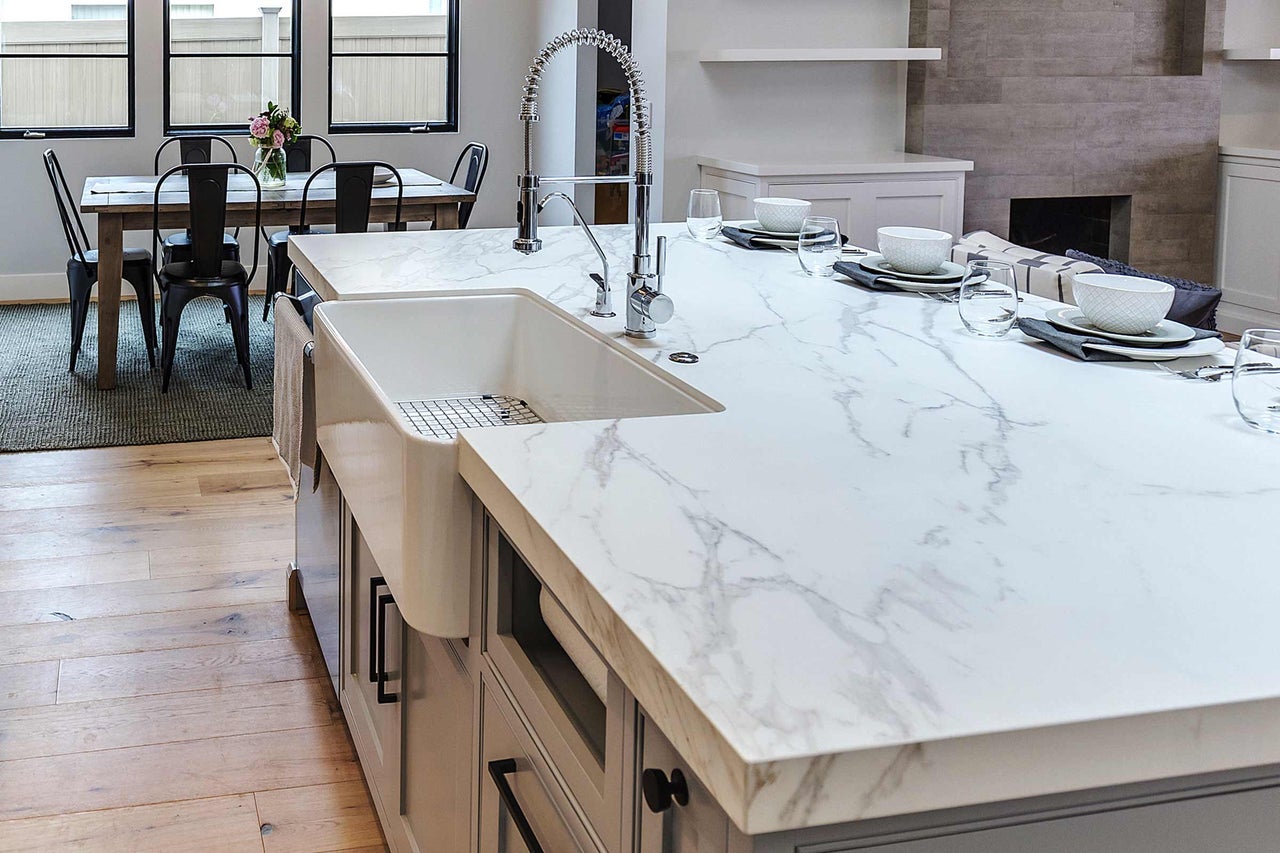 Cuisine lumineuse avec plan de travail en marbre, évier et coin repas