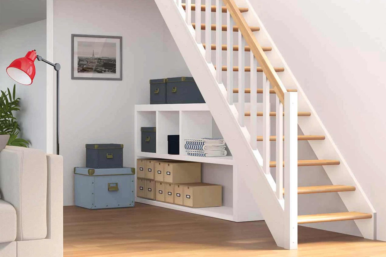 Espace de vie avec escalier, étagère et boîtes de rangement.