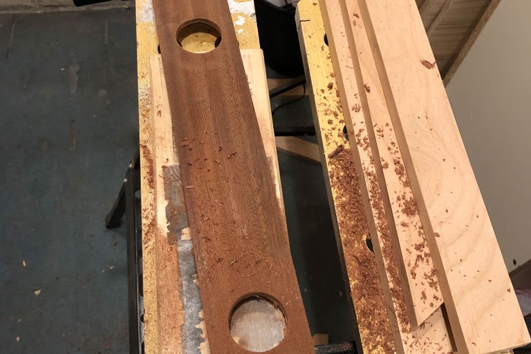 Planche en bois avec deux trous et copeaux de bois