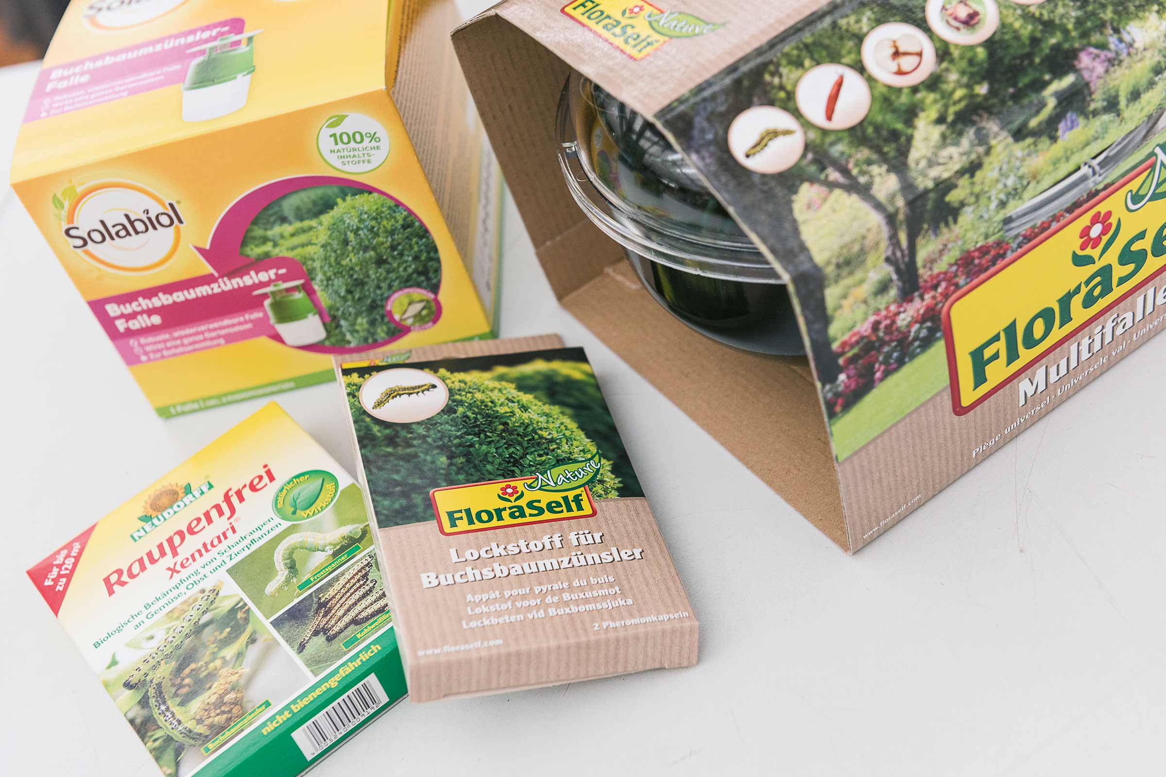 Divers produits de lutte contre les parasites dans le jardin : piège à pyrale du buis, Raupenfrei Xentari et attractif pour pyrale du buis.
