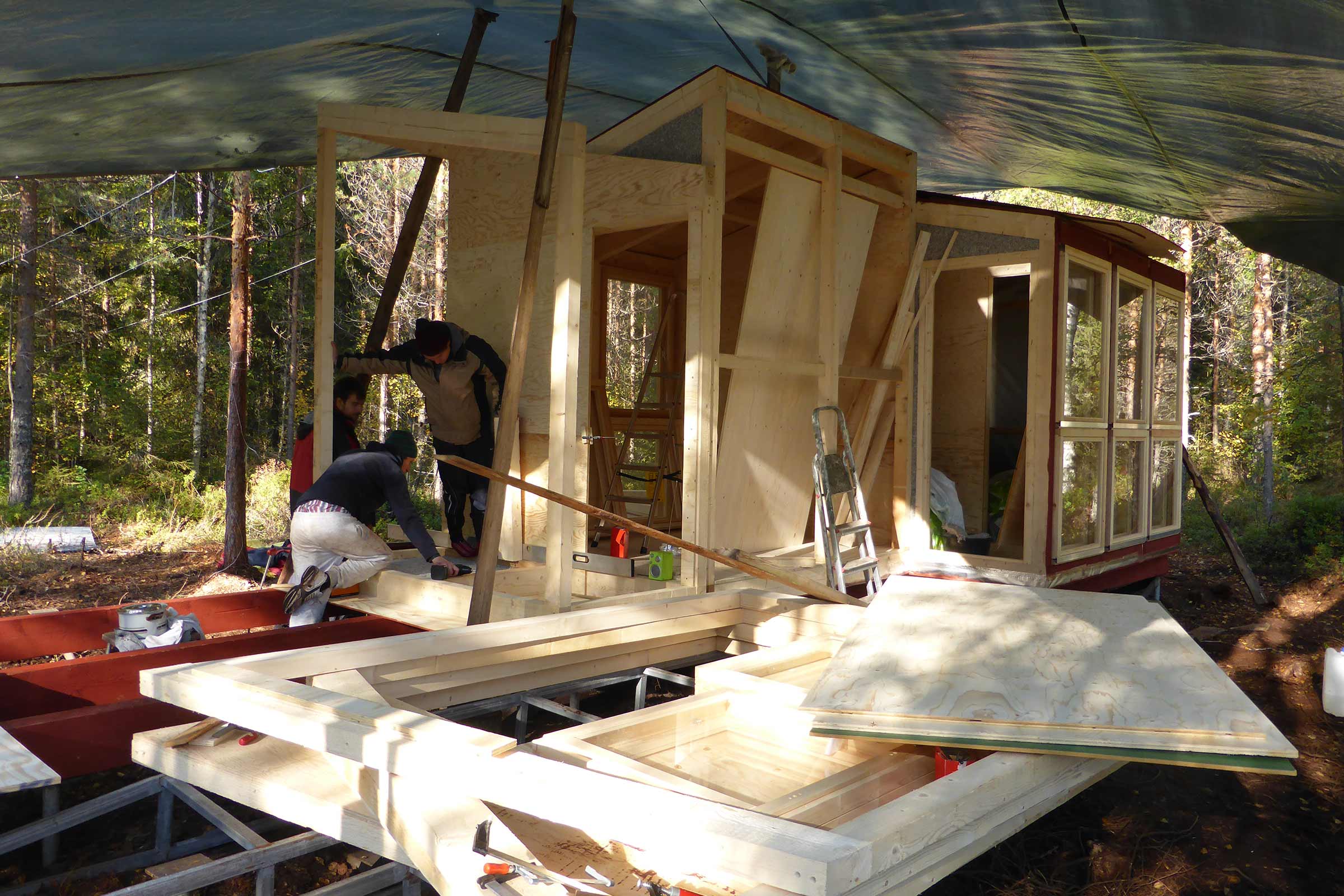 Travaux de construction d'une maison en bois à l'extérieur avec plusieurs personnes