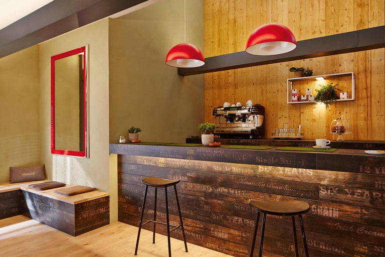 Salle de réception avec bar en bois, tabourets de bar et éclairage rouge