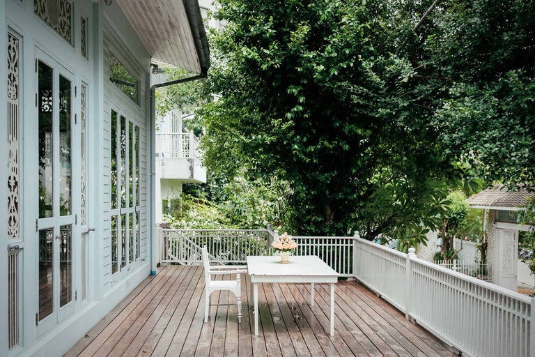 Véranda avec plancher en bois, table, chaise et rambarde
