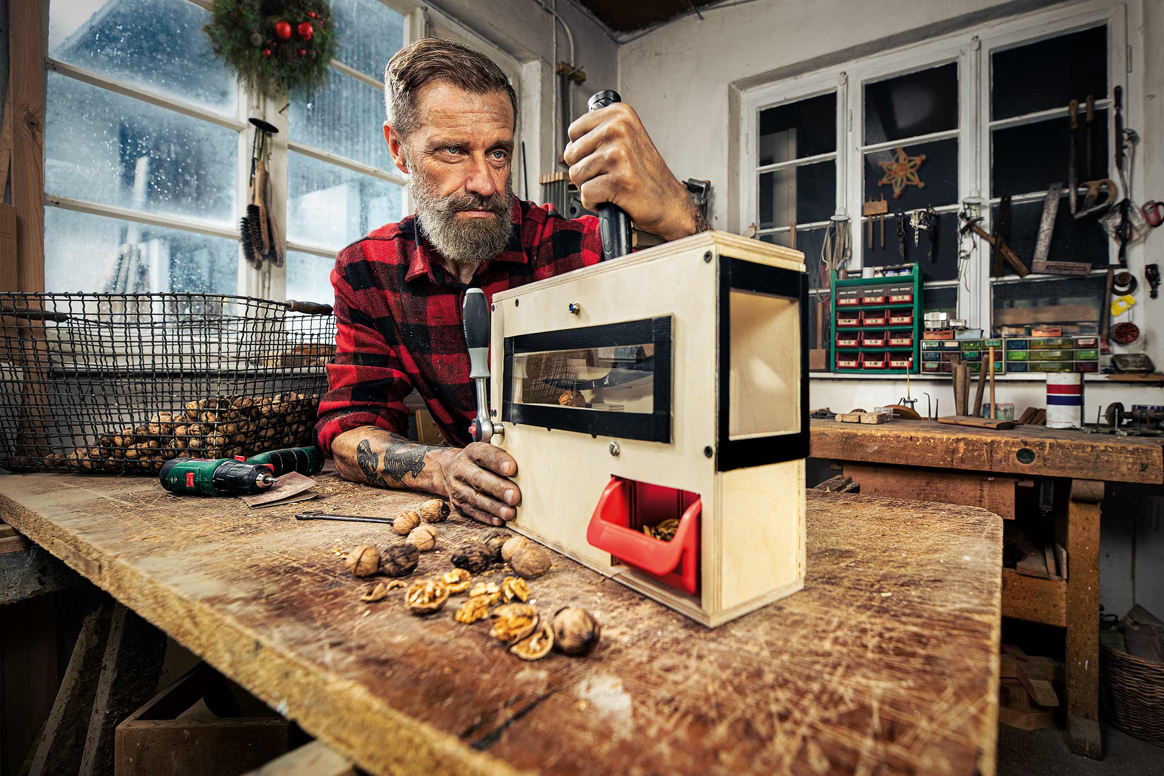 Mann bedient Nussknacker-Maschine in Werkstatt.