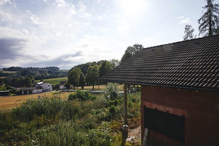 Landschaftsansicht mit Haus im Bau mit Dachziegeln.