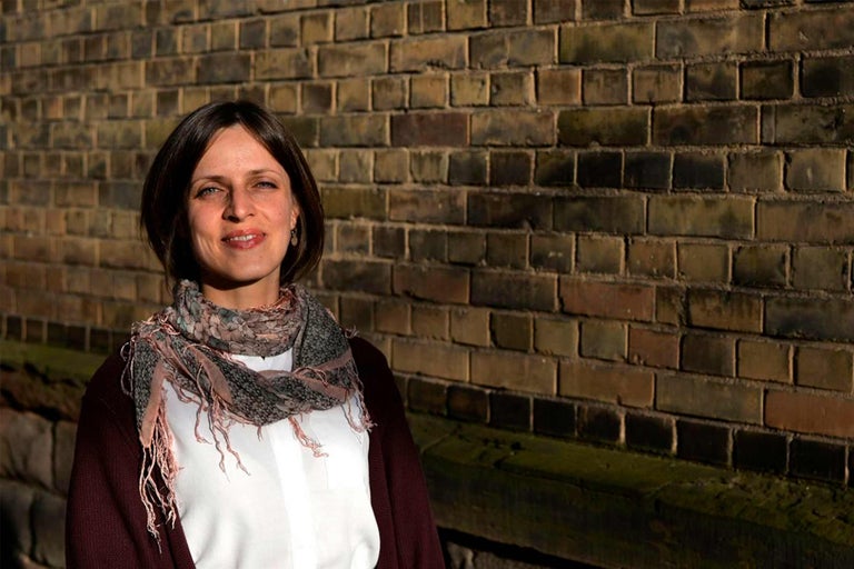 Portrait d'une femme portant un foulard devant un mur de briques