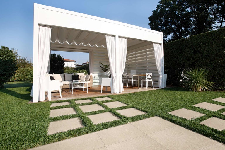 Gartenpavillon mit Terrassenmöbeln und Steinplattenweg im Garten