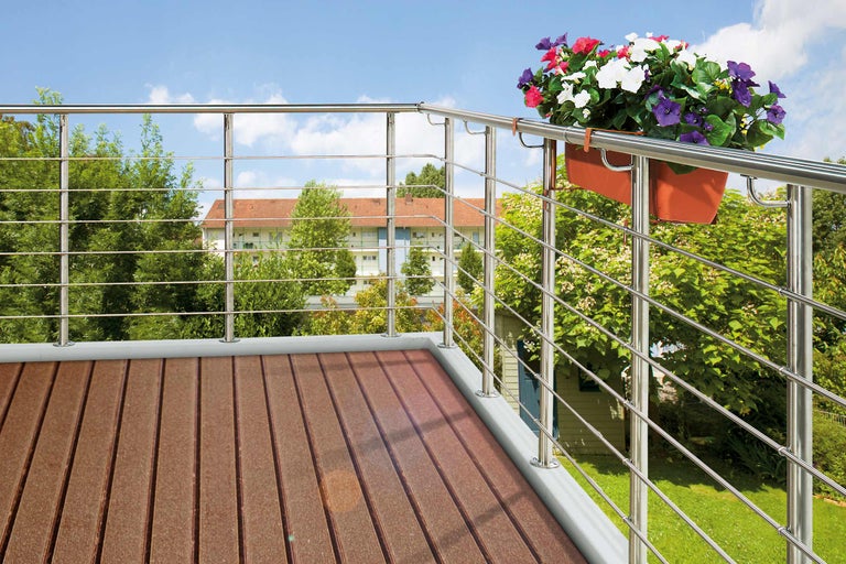 Balcon avec plancher en bois brun et balustrade en acier inoxydable ainsi que jardinière