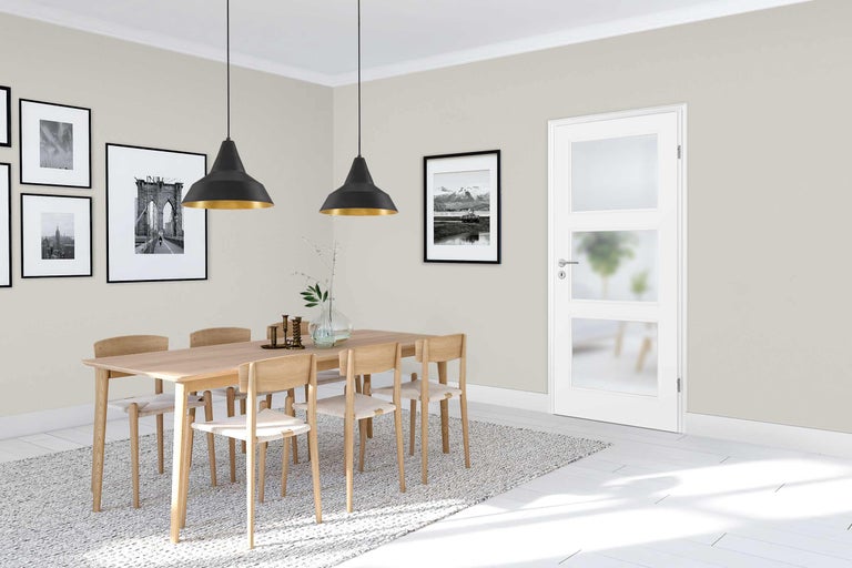 Heller Essbereich mit Holztisch, Stühlen und weisser Innentür mit Glaseinsätzen.