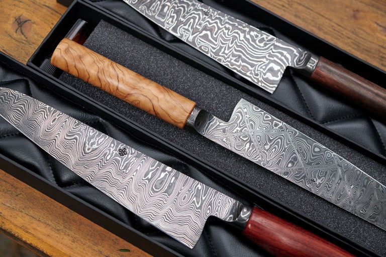 Trois couteaux damassés avec manches en bois dans une boîte cadeau