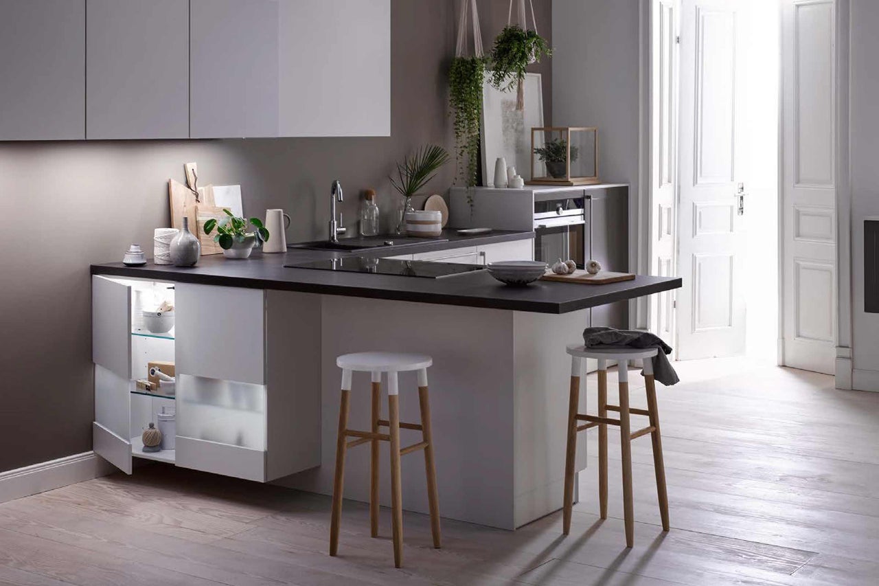 Cuisine claire avec îlot, tabourets de bar et porte ouverte