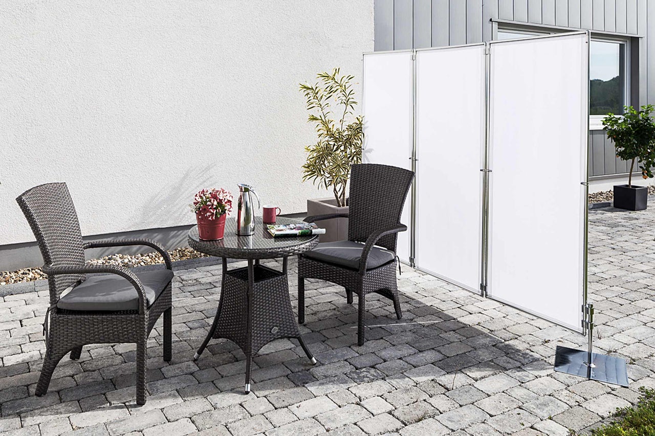 Terrasse mit Rattanmöbeln und Sichtschutz