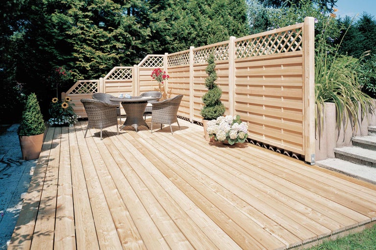 Terrasse en bois avec écran d'intimité et mobilier de jardin.