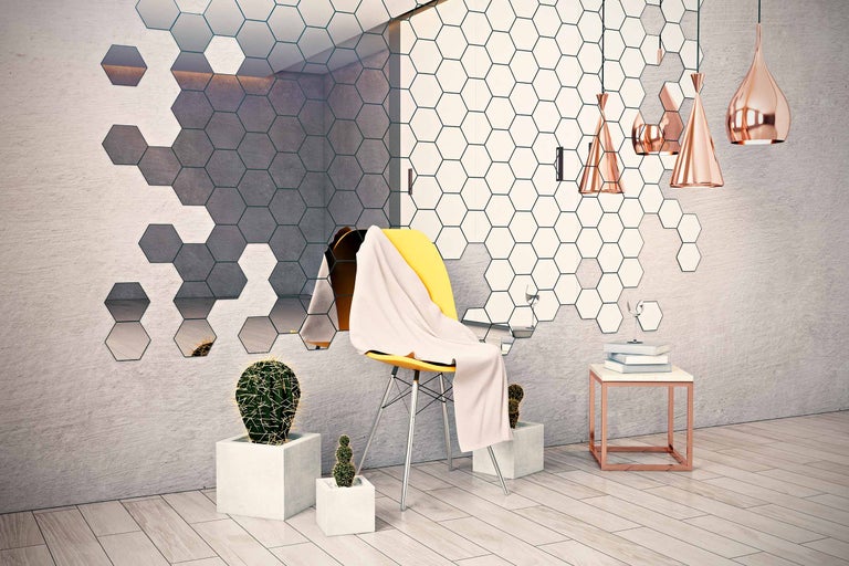 Wohnraum mit sechseckigen Wandfliesen, gelbem Stuhl, Kakteen und Pendelleuchten