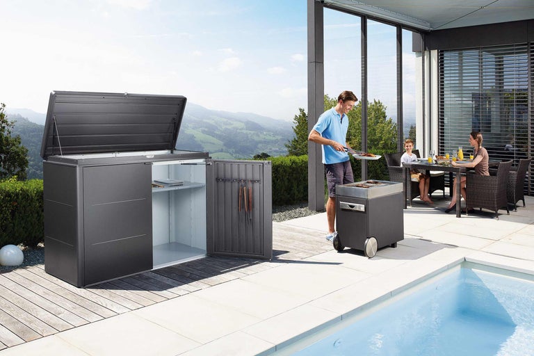 Terrasse avec coffre de rangement, barbecue et famille mangeant à l'extérieur